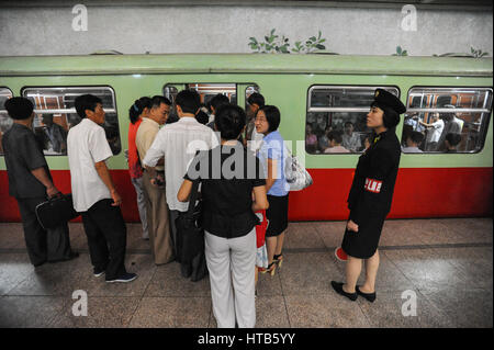 09.08.2012, Pyongyang, Corea del Nord - Una piattaforma supervisore sorge accanto alla metropolitana di attesa in corrispondenza di una stazione di Pyongyang. Foto Stock
