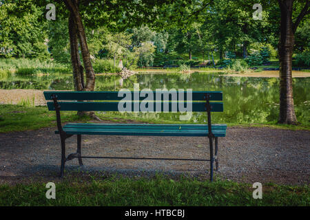 Una panchina nel parco ombreggiato sotto gli alberi in Halifax Giardini Pubblici, Halifax, Nova Scotia, Canada. Foto Stock