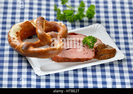 Bavarese di cibo da asporto: Fette di polpettone caldo con senape dolce e un pretzel su un piatto di carta Foto Stock