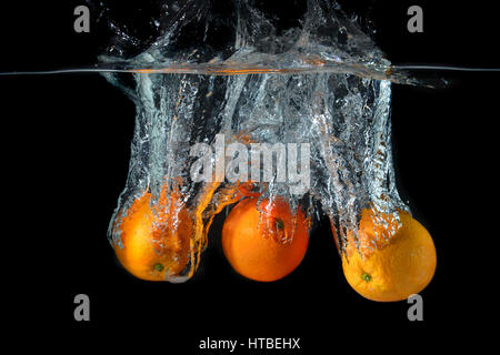 Schizzi d'acqua scende le arance e arte miscelati in studio tecnico e di velocità di illuminazione. Foto Stock