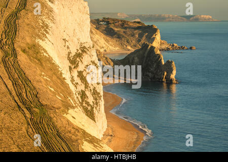 Durdle porta e St Oswald's Bay da Bat la testa al tramonto, Purbeck, Jurassic Coast, Dorset, England, Regno Unito Foto Stock