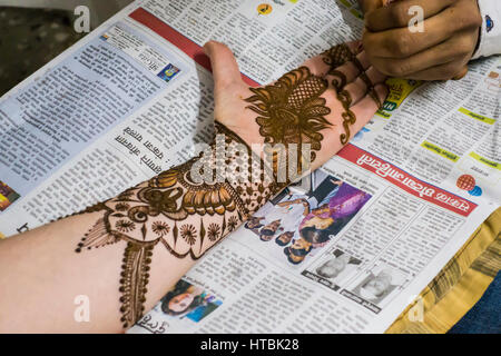 Henna essendo applicato ad un braccio di womans, la mano e le dita da parte di un artista Mehndi in preparazione per una cerimonia di matrimonio. Pune, India. Foto Stock