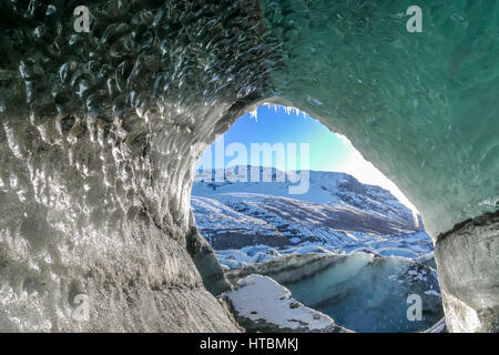 Foro naturale di fusione del ghiaccio nella lingua di Svinafellsjokulsvegur del Ghiacciaio di Vatnajökull in Islanda in inverno con cielo blu Foto Stock