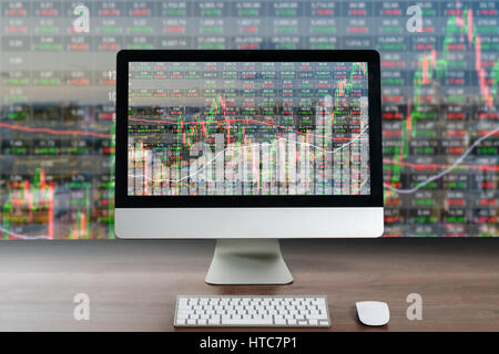 Computer aziendale sulla tavola di legno che mostra attività trading grafico con cityscape edificio in background, di negoziazione il concetto di tecnologia Foto Stock
