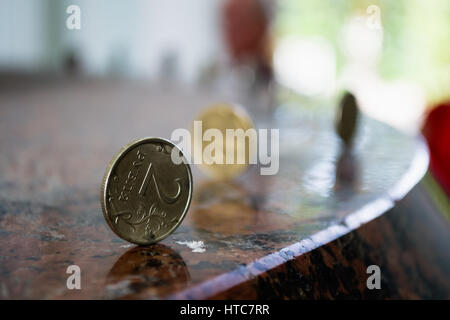 Due russo-ruble-coin in piedi dal bordo sul tavolo di granito Foto Stock