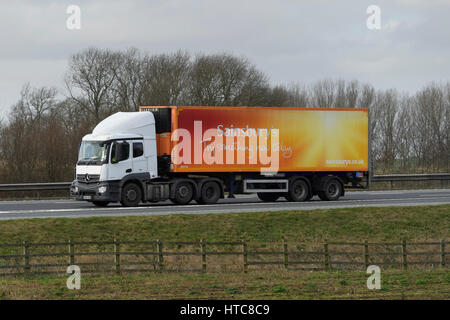 Distribuzione, trasporto e logistica - autocarri articolati (automezzi pesanti HGV, slogan di Sainsbury) che viaggiano sull'autostrada A1 - Inghilterra, GB UK. Foto Stock