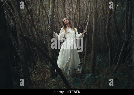 Giovane donna romantica in una desolazione autunno foresta . Innocenza e solitudine Foto Stock