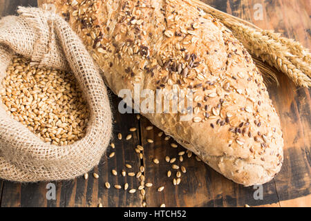 Pane integrale da tutto il frumento, segala e semi di lino in legno rustico sfondo. Foto Stock