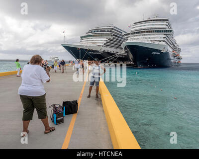 Un americano africano donna assume una fotografia del suo amico in posa di fronte della Holland America Navi da Crociera di Grand Turk Foto Stock