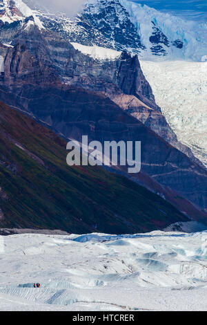 People on Root Glacier a Wrangell-St Elias Parco Nazionale sono nani dal paesaggio circostante, tra cui la massiccia scalinata Icefall nel ... Foto Stock