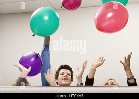 Ufficio lavoratori giocando con palloncini Foto Stock
