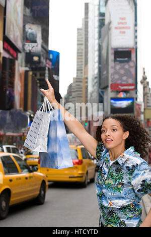 Donna salutando giallo taxi Foto Stock