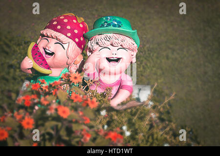 Focus su:scultura in argilla o bambola di ceramica,un ragazzo e una ragazza che ama ridere nel giardino/decorazione<processo colore> Foto Stock