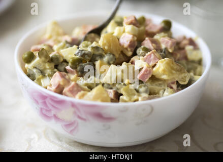 In casa insalata olivie nella ciotola sul tavolo. Olivier insalata è un tradizionale piatto di insalata in cucina russa, che è popolare anche in molti altri paesi europei. Decimo Mar, 2017. In diverse ricette moderne, è solitamente realizzato con cubetti di patate bollite, carote, messi in salamoia dill pickles, piselli verdi, uova, sedano rapa, cipolle, crostata di mele con sale e pepe, conditi con maionese Credit: Igor Golovniov/ZUMA filo/Alamy Live News Foto Stock