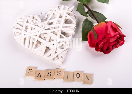 Una rosa rossa con un cuore bianco e la parola 'passione' Foto Stock