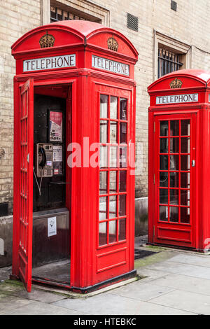 Due cabine telefoniche rosse di Londra, uno con sportello aperto. Foto Stock
