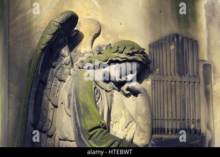 Il pianto angel organista statua nel cimitero Malostransky, Praga, Repubblica Ceca Foto Stock