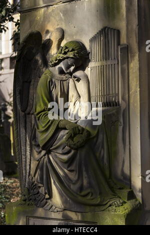 Il pianto angel organista statua nel cimitero Malostransky, Praga, Repubblica Ceca Foto Stock