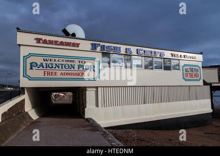 Detectorists metallo sul rilevamento di Paignton Beach con Frgate o nave da guerra ormeggiata in Torbay con Berr testa in background Foto Stock