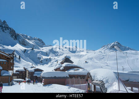 Gli sciatori passano attraverso Belle Plagne ski resort village in Savoia, sulle alpi francesi Foto Stock