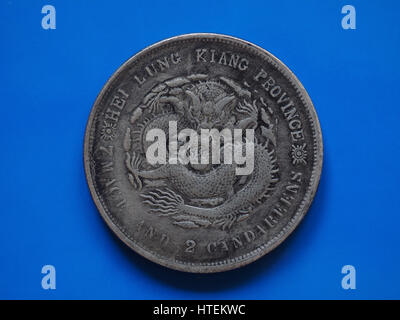 Vintage cinese argento 7 macis e 2 Candereens moneta da polmone di Kiang Provincia in Cina, circa 1889 su sfondo blu Foto Stock
