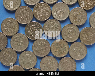 Una libbra di monete denaro (GBP), valuta del Regno Unito su sfondo blu Foto Stock