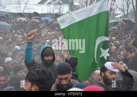 Srinagar, India. 09Mar, 2017. Kashmir uomo musulmano pakistano onde bandiera durante il corteo funebre di Hizb Rebel Mushtaq Ahmad veggente al suo villaggio natale Malangam Bandipora il 10 marzo 2017. Mushtaq è stato ucciso in un breve incontro con le forze di governo giovedì sera al centro principale Bandiopora area del Nord Kashmir Credito: Mohammad Abu Bakar/Pacific Press/Alamy Live News Foto Stock