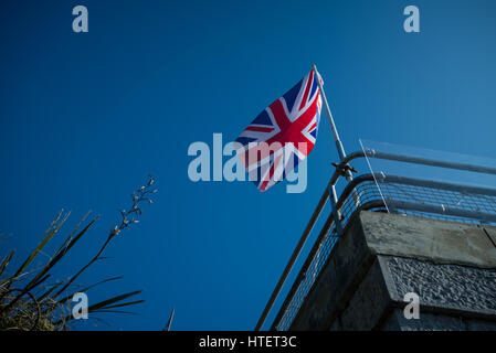 Un union jack sventola bandiera nella brezza contro un cielo blu chiaro. Foto Stock