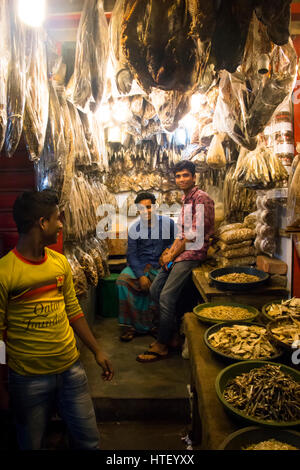 CHITTAGONG, BANGLADESH - Febbraio 2017: Persone con un piccolo negozio che vende pesce essiccati nel bazar centrale mercato di Chittagong, Bangladesh Foto Stock