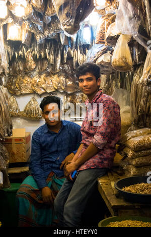 CHITTAGONG, BANGLADESH - Febbraio 2017: Persone con un piccolo negozio che vende pesce essiccati nel bazar centrale mercato di Chittagong, Bangladesh Foto Stock