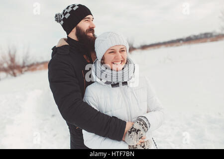 Ragazzo barbuto abbracci la sua ragazza da dietro. Essi hanno un grande tempo sulle vacanze invernali Foto Stock