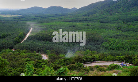 Un paesaggio fantastico di strada attraverso la giungla di Lam Dong, Vietnam, panoramica Scena verde con la messa in movimento del veicolo sul percorso di polvere a croce mountain pass della foresta Foto Stock