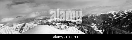 Bianco e nero panorama di fuori-pista pendio nevoso e nuvoloso montagne. Montagne del Caucaso, Georgia, regione Gudauri d'inverno. Foto Stock