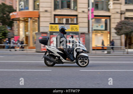 Biker in sella a una Yamaha bianco tricity 125 nella Gran Via a Madrid (Spagna) 2017. Foto Stock