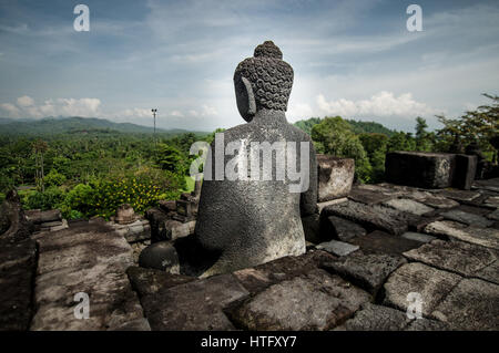 Statua di Buddha che si affaccia sul sito del tempio di Borobudur in Java centrale, Indonesia Foto Stock