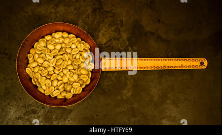 Green i chicchi di caffè prima di frittura in un rame padella vista superiore Foto Stock