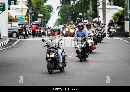 Ciclomotori attraversando una giunzione occupato nel centro di Yogyakarta - Java, Indonesia Foto Stock