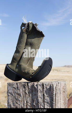 Un cowboy che ha ottenuto il suo denaro vale la pena al di fuori di questo vecchio boot inchiodati in un post, Vananda, MT. Foto Stock