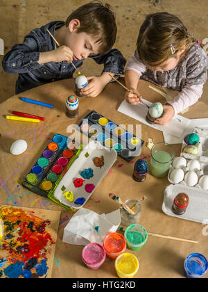 Foto di un fratello e una sorella di pittura e decorazione di uova sode per la Pasqua. Foto Stock