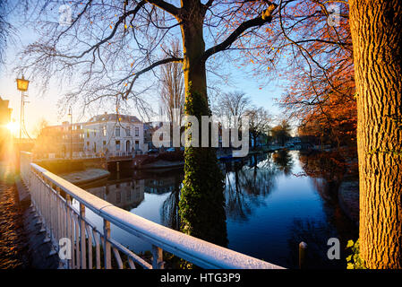 Sunrise vista lungo il ponte attraverso uno dei canal a Utrecht, con la neve e i colori dell'autunno Foto Stock