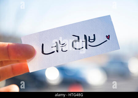 Dita tenere la lingua coreana calligraphy : "sei amore" Foto Stock