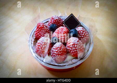 Una piccola torta di fragole sul tavolo Foto Stock