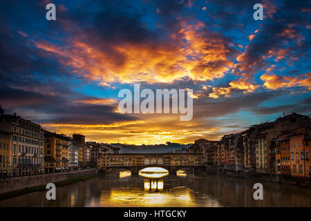 Cancellazione di nuvole temporalesche all'alba crea un drammatico tramonto su Ponte Vecchio a Firenze, Italia Foto Stock