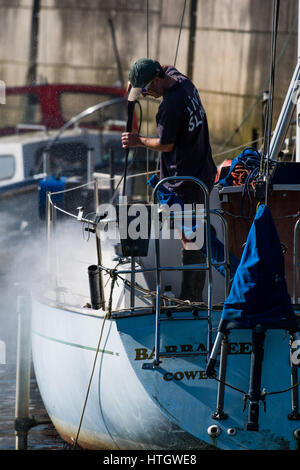 Aberystwyth Wales UK, Mercoledì 15 Marzo 2017 UK Meteo: un uomo pulizia di primavera la sua barca a vela nel porto in un giorno di cielo azzurro brillante e ininterrotte caldo sole primaverile in Aberystwyth Wales Photo credit: Keith Morris/Alamy Live News Foto Stock
