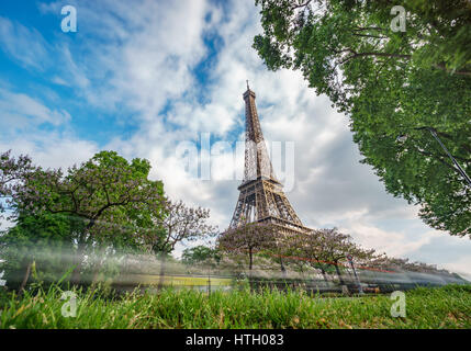 Ampio angolo di Torre Eiffel con auto sentieri e cielo nuvoloso, con esposizione lunga Foto Stock