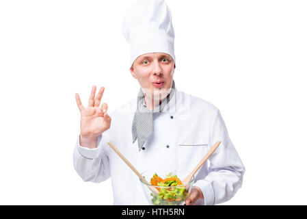 Ammirate lo chef con insalata in mani che mostra il gesto a mano su sfondo bianco Foto Stock