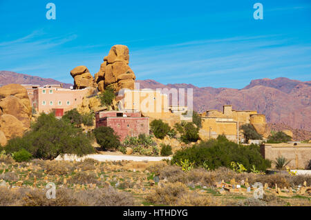 Cimitero, formazioni rocciose, case residenziali e Anti Atlas Mountains, Route de Tazekka, Tafraout, Marocco Foto Stock