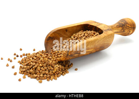 Chicchi di grano saraceno in legno da scoop su sfondo bianco Foto Stock