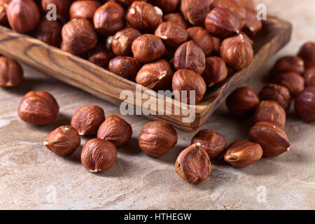 Le nocciole in legno vecchio piatto su un tavolo da cucina Foto Stock
