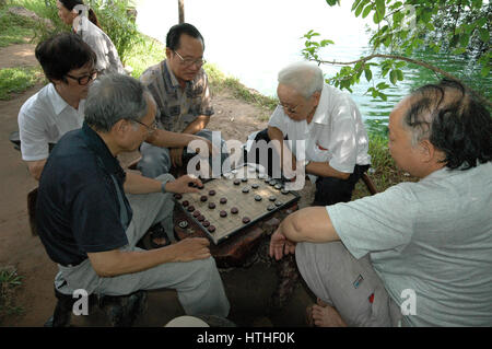 Gli uomini anziani giocare a scacchi al marciapiede ad Hanoi, Vietnam Foto Stock